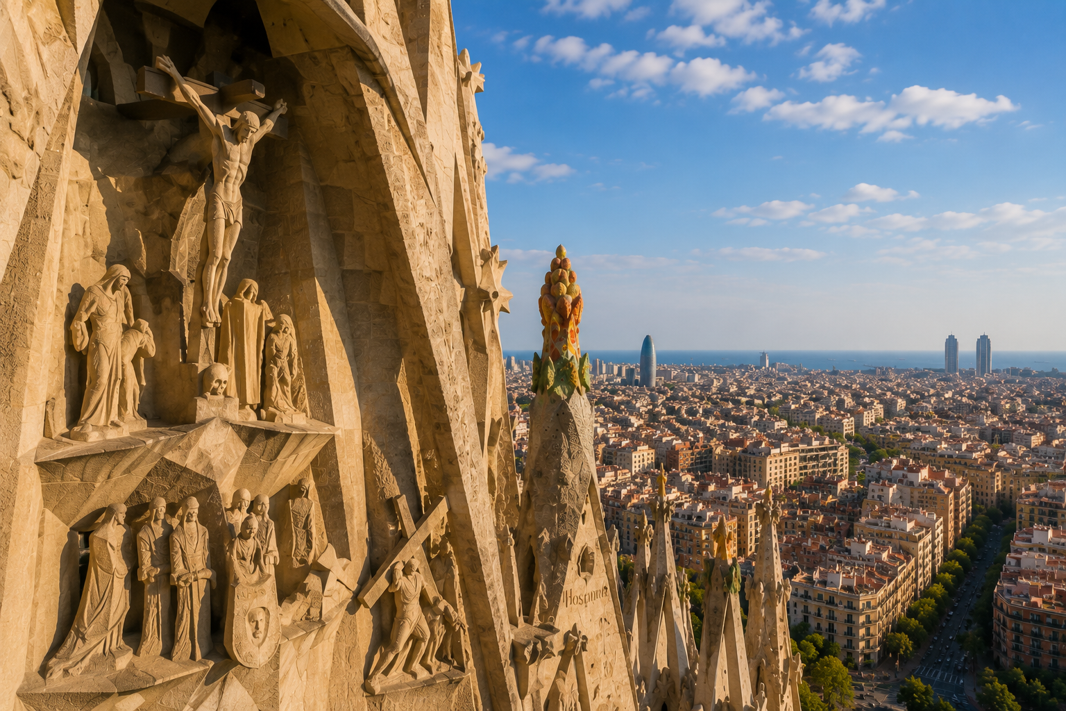 Sagrada Família tower architecture with detailed sculptures and panoramic views across Barcelona toward the Mediterranean Sea.